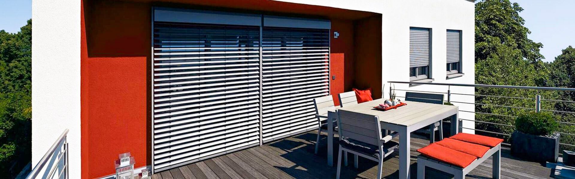 Moderne Terrasse mit elektrisch steuerbaren Raffstores an großen Glasfronten
